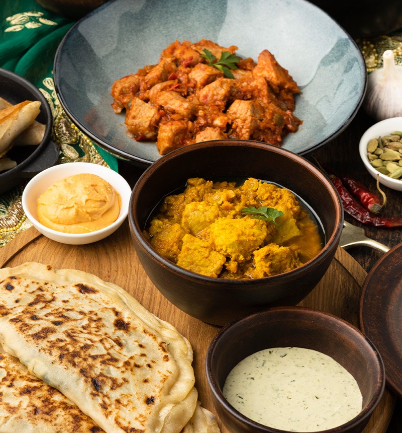 Indische Currys mit Naan-Brot und Dips