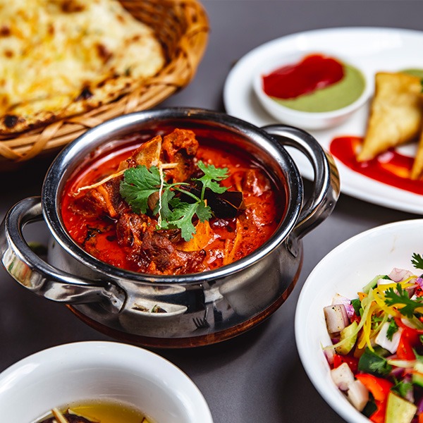 Indisches Curry mit Naan und Beilagen